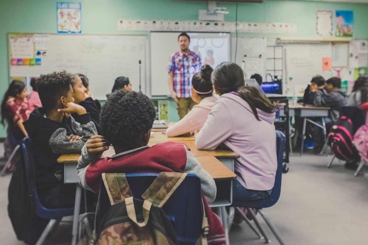 Enseignant présentant un cours devant des élèves attentifs dans une salle de classe