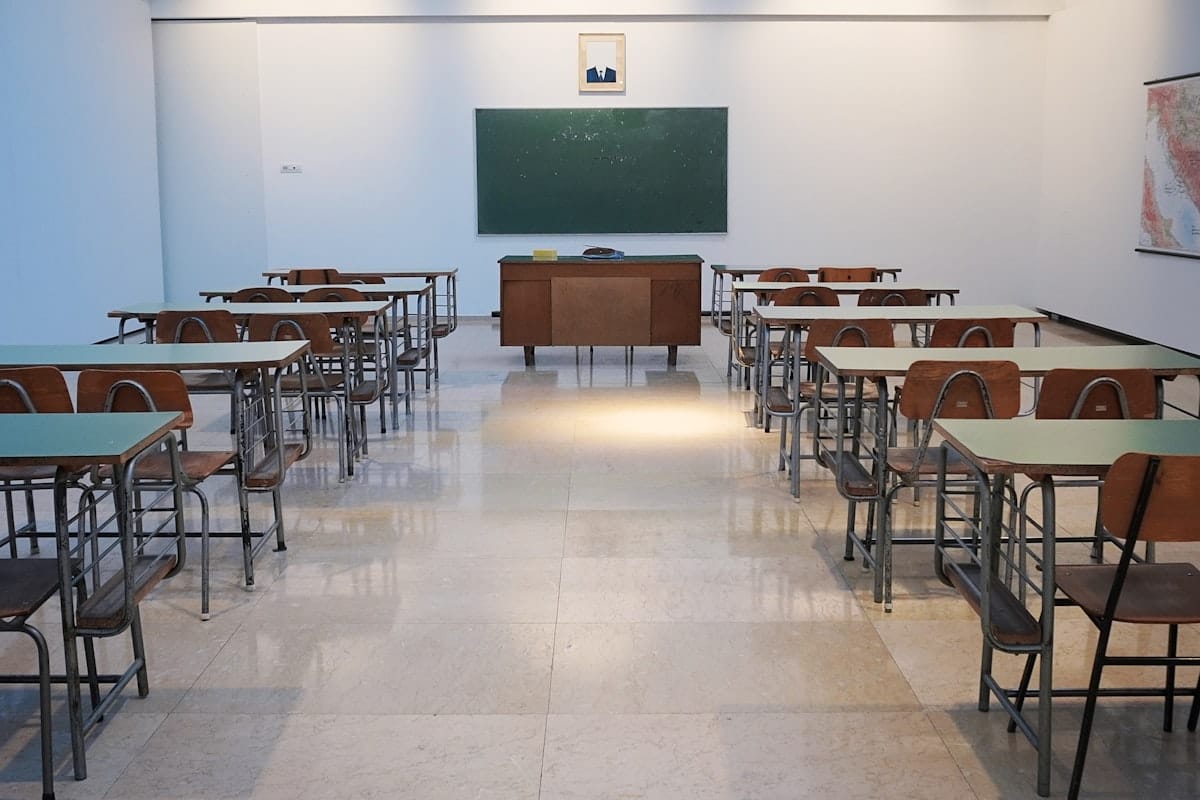 Salle de classe vide avec un tableau noir et des bureaux d'écoliers